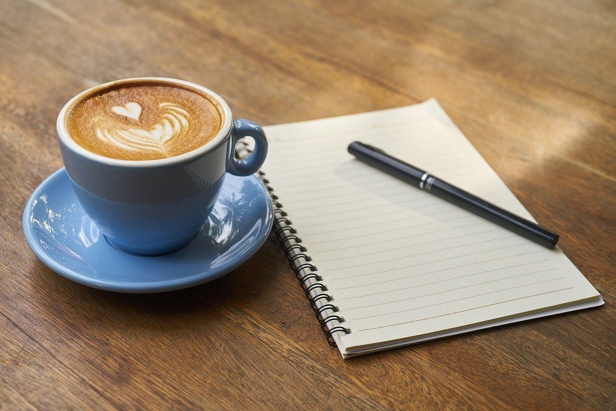 Sonhar com caderno em branco Sonhar com caderno em branco: imagem de um caderno com café e caneta