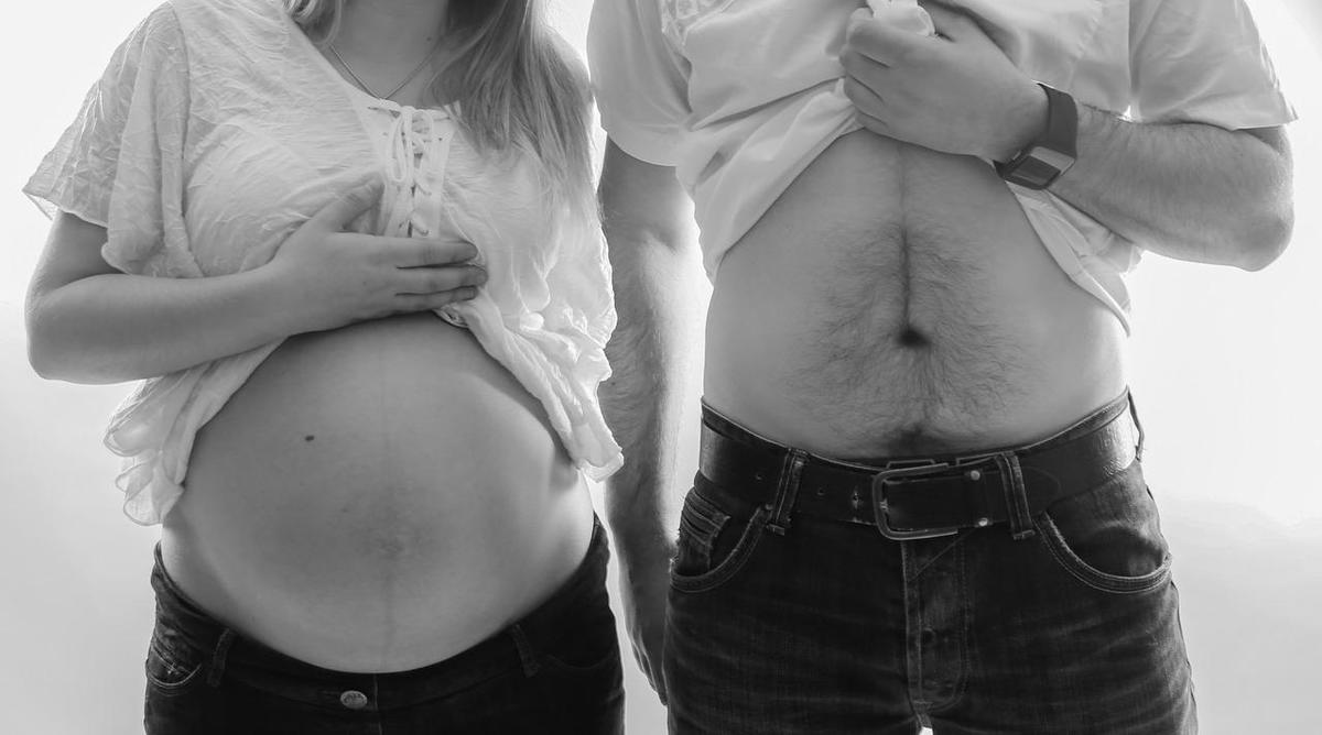 Sonhar com amiga grávida do marido: imagem de uma mulher grávida e um homem mostrando a barriga