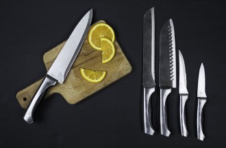 Muitas facas com tábua de corte de madeira